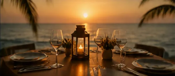 Candlelit table on the sand at sunset