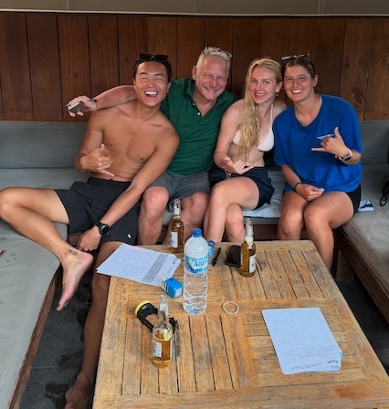 Four divers laughing together on a lounge after a day on the water